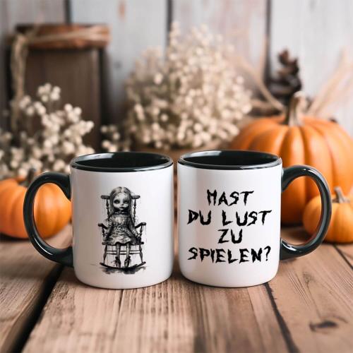 Zweifarbige Tasse zu Halloween, Horrorpuppe und Spruch: Hast du Lust zu spielen? Beidseitig bedruckt, schwarz-weiß glänzend, Füllmenge: ca. 330 ml, Spülmaschinen- und Mikrowellengeeigent, Beispiel