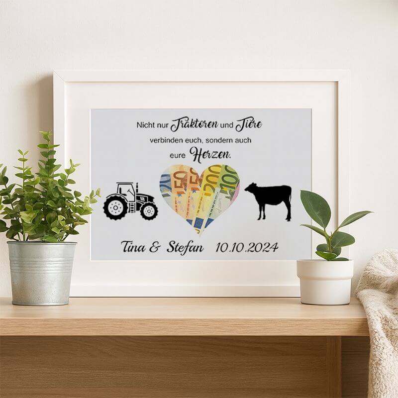 Weißer Bilderrahmen mit Spruch und ausgeschnittenem Herz aus Pappe, Motiv mit Traktor und Kuh, personalisiert mit Namen, dekorativ auf Holzregal mit Pflanzen präsentiert