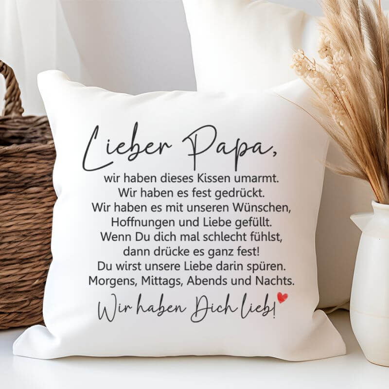 Dekorativ arrangiertes Kuschelkissen „Lieber Papa – Kissen umarmt“ in Wir-Form mit liebevollem Spruch.