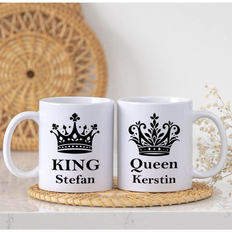 Hier ein Produktbild von den King und Queen Tassen. Die Tassen stehen auf eine Unterlage aus Holz.