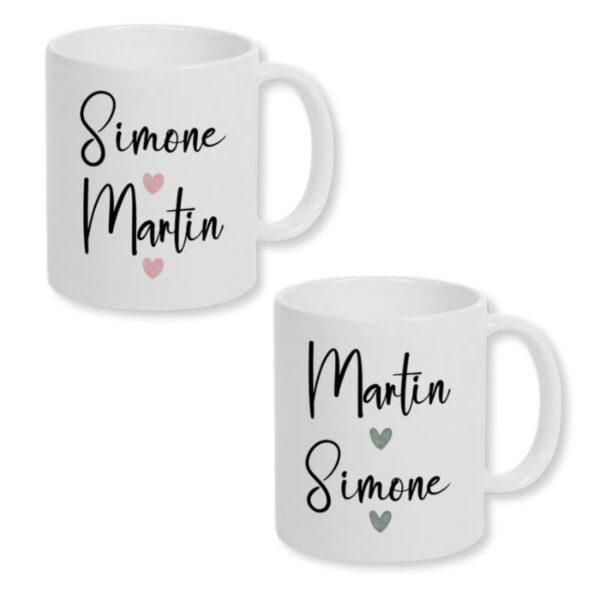 Partnertassen mit Wunschnamen. Zwei weiße Keramiktasse mit einem Print mit den Namen des Paares und zwei Herzen im Watercolor-Design. Für die Frau mit rosafarbenen Herzen und für den Mann mit grauen Herzen. Der Print befindet sich auf beiden Seiten der Tassen.