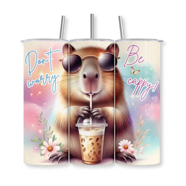 Thermobecher mit Capybara-Motiv „Don't worry, be cappy!" – schlanker Edelstahl-Tumbler mit Strohhalm, bedruckt mit einem coolen Capybara mit Sonnenbrille, das einen Eiskaffee trinkt, pinke und türkise Farbflächen mit Blumendetails – Geschenkidee von Majas Geschenkewelt